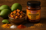 create hd image of raw mango pickle with raw mango and spices surrounding along with mango pickle packet with written on Spruha’s Gharguti khandeshi Kari pickle